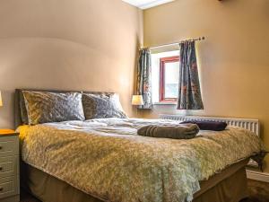 a bedroom with a bed and a window at Ladycroft House in Hebden