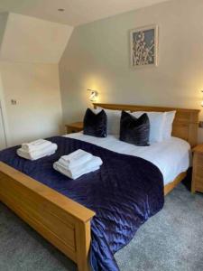 a hotel room with a large bed with towels on it at The Holiday Hoose in Kinghorn +51 photos