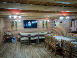 uma sala de jantar com mesas e cadeiras e uma parede de tijolos em Hanu lu’ Vasile em Breb