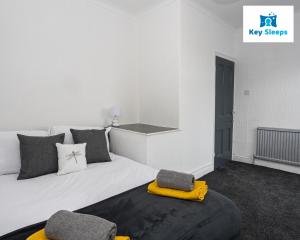 a bedroom with a large white bed with a yellow blanket at Stylish House By Keysleeps Central&Free Parking&Games Room At St Helens in Saint Helens