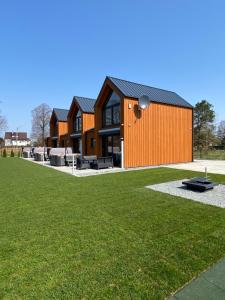 a house with a large yard with green grass at Apartamenty MarMar in Sławoszynko