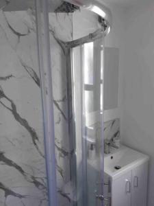 a shower with a glass door next to a sink at The Holiday Hoose in Kinghorn