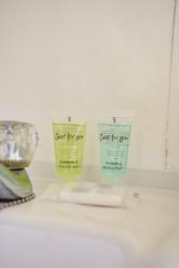 three bottles of just for soap sitting on a counter at Rotherwood Apartment in Glasgow