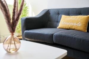 a living room with a blue couch and a vase on a table at Rotherwood Apartment in Glasgow