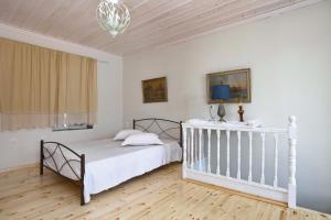 een witte slaapkamer met een bed en een televisie bij House of town in Skopelos Town