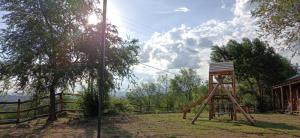 une structure en bois assise dans l'herbe à côté d'une clôture dans l'établissement Sommerwind Cabañas, à La Estancia