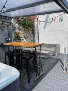 a wooden table and chairs on a deck at The Holiday Hoose in Kinghorn