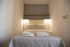 a bedroom with a bed with two towels on it at Hotel Explorer in Cervia