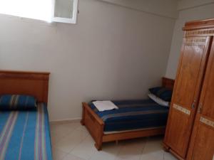 a small bedroom with two beds and a cabinet at KHAOULA in Rabat