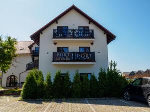 a building with a sign for a hotel at PORT 77 in Krynica Morska