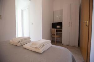 a white room with a bed with white towels on it at Hotel Explorer in Cervia