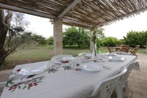 ein Tisch mit einer weißen Tischdecke und weißem Geschirr darauf in der Unterkunft Villa Il Gelso - San Foca in San Foca + 15 Fotos