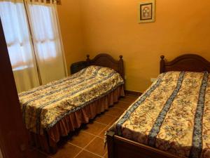 a bedroom with two beds and a window at La casa de Mamina in Tilcara