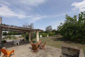 eine Terrasse mit einem Holztisch und Stühlen in der Unterkunft Villa Il Gelso - San Foca in San Foca