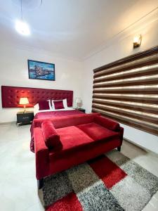 sypialnia z dużym czerwonym łóżkiem z czerwonym zagłówkiem w obiekcie Montreal Suite by Jaynice Homes w mieście Lekki