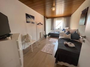 ein Wohnzimmer mit einem Bett und einem Sofa in einem Zimmer in der Unterkunft ERH03-FW Flat in Herzogenaurach in Herzogenaurach