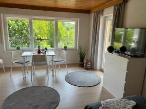 ein Wohnzimmer mit einem Tisch und einem TV in der Unterkunft ERH03-FW Flat in Herzogenaurach in Herzogenaurach