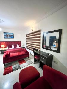 sypialnia z czerwonym łóżkiem i czerwoną kanapą w obiekcie Montreal Suite by Jaynice Homes w mieście Lekki