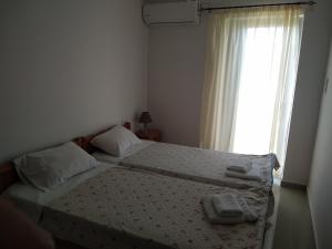 a bedroom with two beds and a window at Hotel Pyrgos in Kounoupidhianá