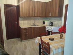 a kitchen with a table and a sink and a microwave at Hotel Pyrgos in Kounoupidhianá