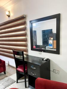 a black desk with a red chair and a mirror at Montreal Suite by Jaynice Homes in Lekki