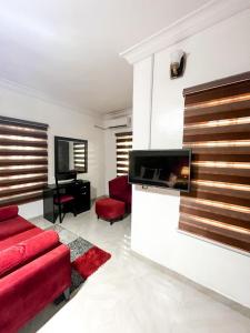 a living room with red furniture and a flat screen tv at Montreal Suite by Jaynice Homes in Lekki