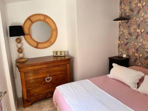 a bedroom with a bed and a mirror on a dresser at Petite maison cosy in Six-Fours-les-Plages