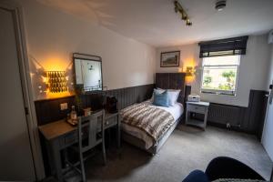 a bedroom with a bed and a desk and a mirror at The Griffin Inn Bath in Bath