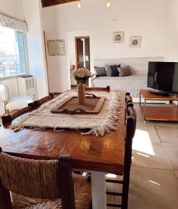 un soggiorno con tavolo in legno e divano di El Cerrito departamento a Tandil
