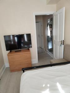 a bedroom with a bed and a flat screen tv at Balfour Street in Bradford