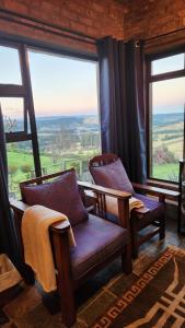 a room with two chairs and large windows at THE VIEWPOINT SUV vehicle required in Howick