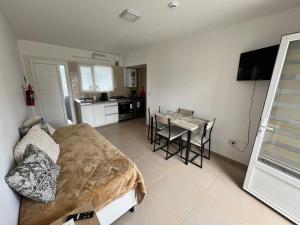 Cet appartement comprend une chambre avec un lit et une table ainsi qu'une cuisine. dans l'établissement Bahía Golondrina 2, à Ushuaia