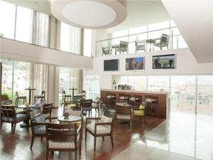 ボゴタにあるHotel bh Usaquénのテーブルと椅子と窓のあるレストラン