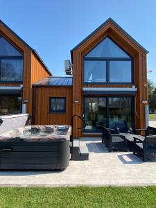 a house with a bed and chairs in front of it at Apartamenty MarMar in Sławoszynko