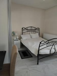 een slaapkamer met een bed met witte lakens en een stoel bij Balfour Street in Bradford