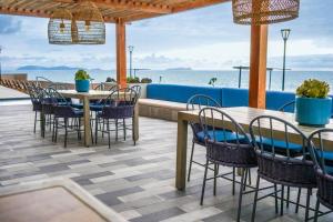 Hotel Suite Luxe Sunset في تيخوانا: فناء به طاولات وكراسي و المحيط