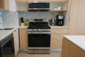 a kitchen with a black stove and a microwave at Hotel Suite Luxe Sunset in Tijuana