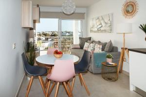 uma sala de estar com uma mesa e cadeiras e um sofá em Apartamento Aguamarina Senator em Costa Teguise