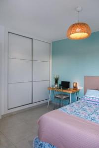 um quarto com uma cama e uma mesa com um computador portátil em Apartamento Aguamarina Senator em Costa Teguise