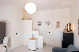 a living room with white walls and a white refrigerator at Casa Claire in San Vito lo Capo