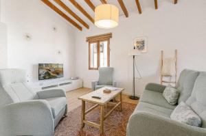a living room with two couches and a table at Townhouse with puig de María view by home villas 360 in Pollença