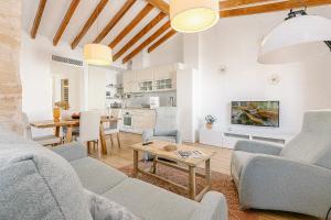 ein Wohnzimmer mit einem Sofa und einem Tisch in der Unterkunft Townhouse with puig de María view by home villas 360 in Pollença