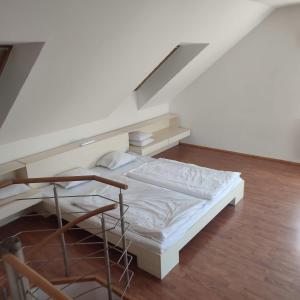 - un lit blanc dans une chambre avec un escalier dans l'établissement Large house with parking, 30 min to Prague center, à Úvaly