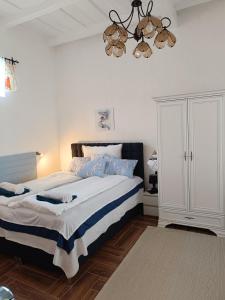 um quarto com uma cama grande e um lustre em Kiskastély Apartman em Balmazújváros