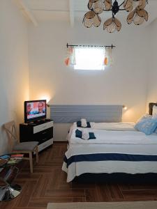 a bedroom with a bed and a flat screen tv at Kiskastély Apartman in Balmazújváros
