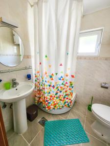 y baño con cortina de ducha y lavamanos. en Villa Blanca, en Utjeha