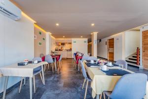 un restaurante con mesas y sillas y una cocina en Hotel Central Merida by Kavia en Mérida