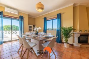 a dining room with a table and chairs and a fireplace at #071 Spacious Seaview with Pool, Tennis Court and AC in Albufeira