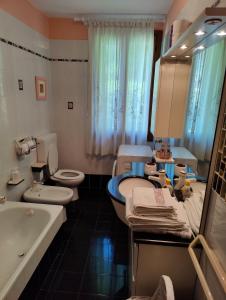 La salle de bains est pourvue de 2 toilettes, d'un lavabo et d'une baignoire. dans l'établissement Casa Vacanze Monte Villa, à Pieve di Soligo