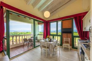 a kitchen and dining room with a table and a balcony at Bertoletta Village Apartments in Peschiera del Garda